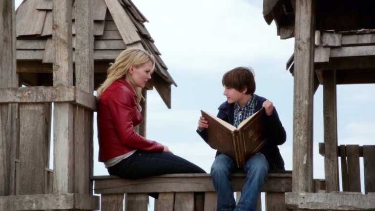 Emma and Henry sit in Henry's play castle with the storybook.